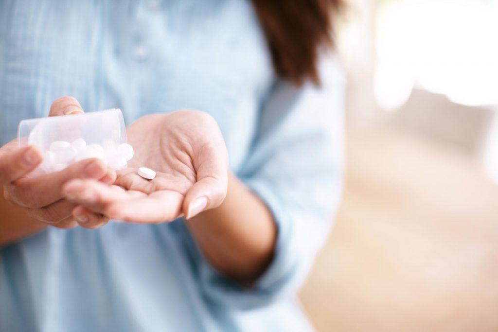 Woman holding Medicines Car sickness causes